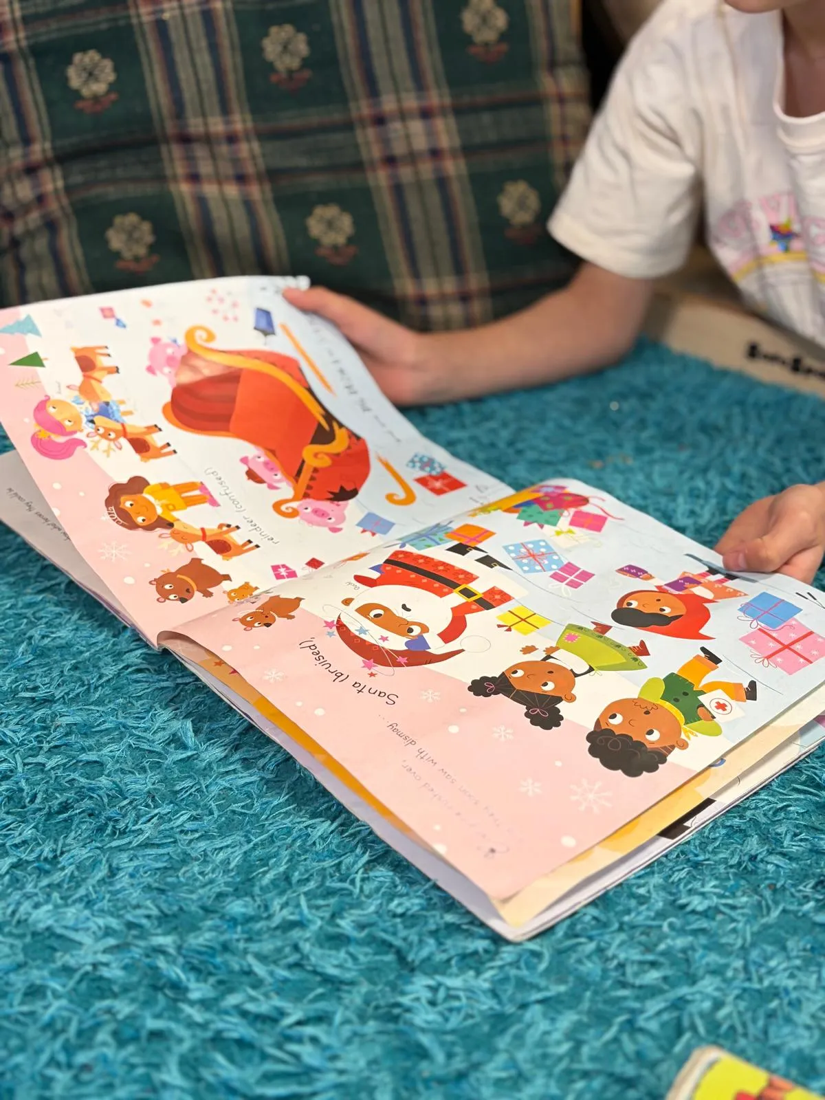 A child turning the pages of a picture book on the mat