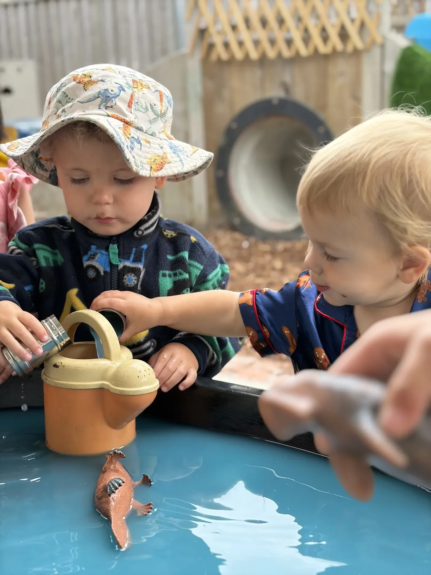 Preschoolers playing with water outside at Wonderhub